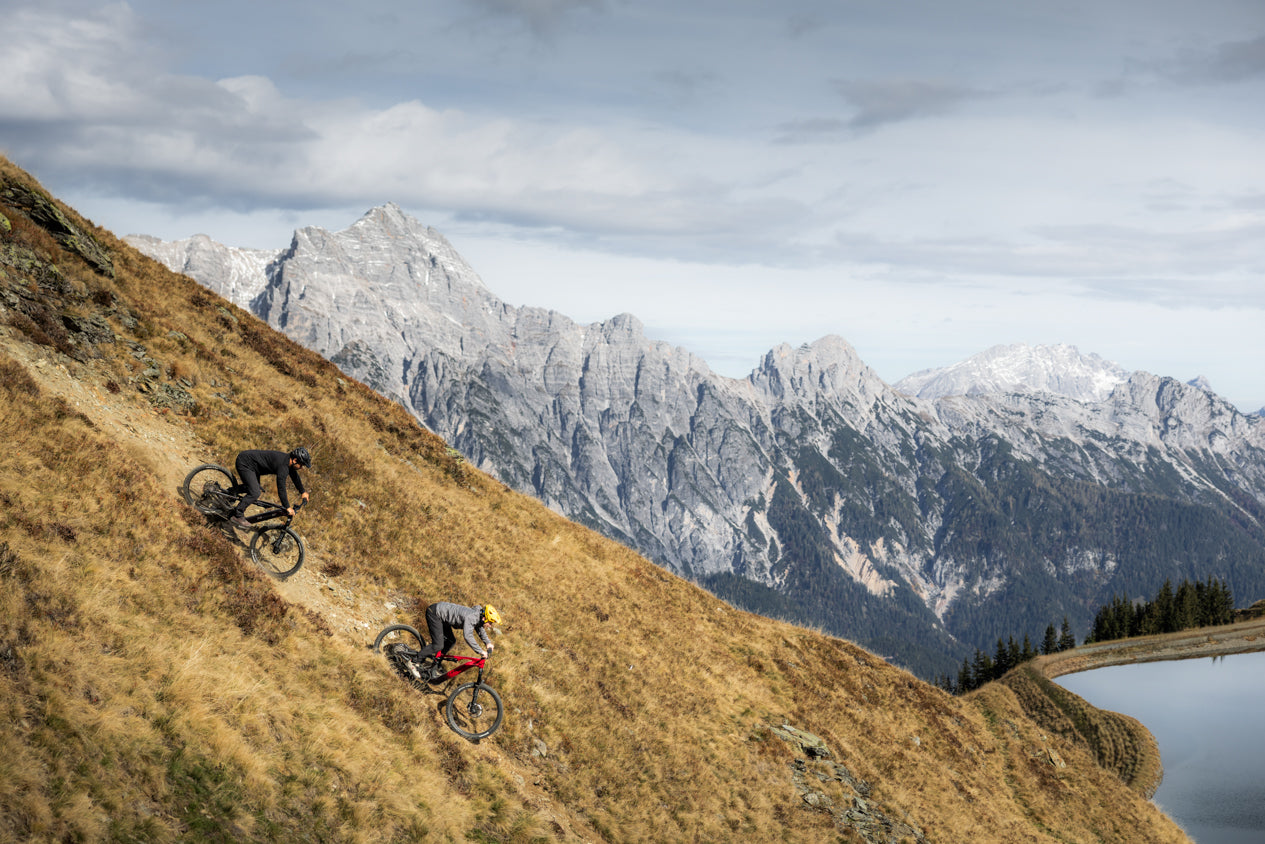To syklister på Haibike el-terrengsykler i et solrikt alpint fjellandskap